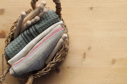 A basket with stacked laundry and clothespins