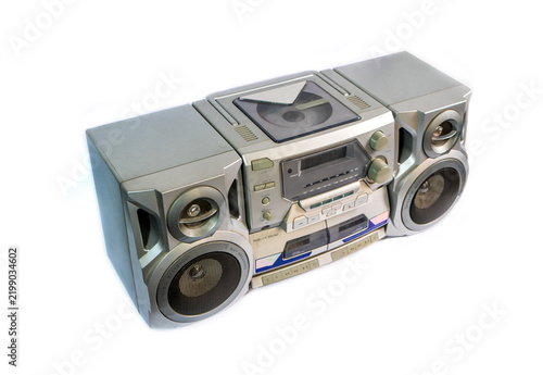 Retro 90s audio tape recorder and mini hi-fi system with radio tuner and dual cassette deck, isolated on an empty white background.