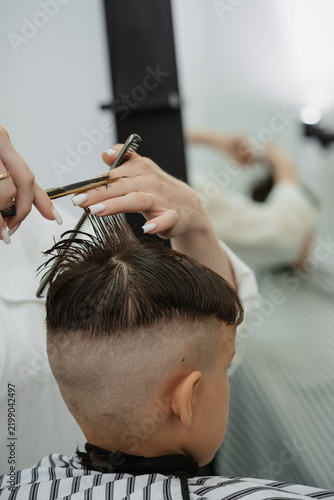 Canvas Print A photo from the life of a hairdresser's client, a dark-haired boy