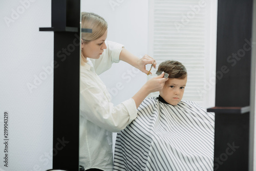 Canvas Print A photo from the life of a hairdresser's client, a dark-haired boy