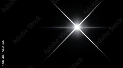 Bright four pointed star flare isolated on black background with lens flare optical effect glowing star