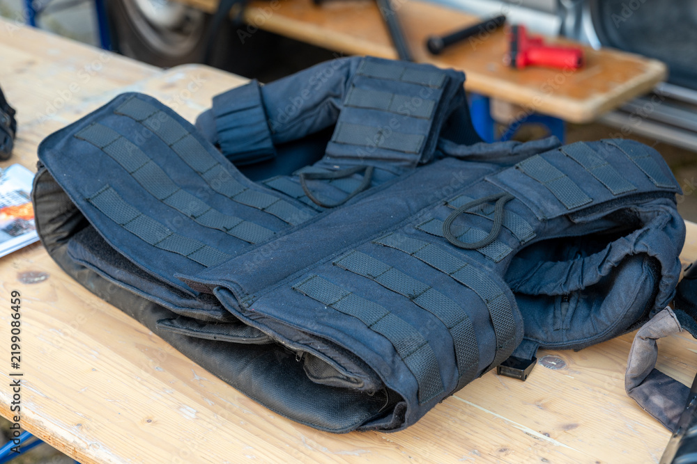 Obraz premium Tactical body armor vest lying on wooden workbench in workshop