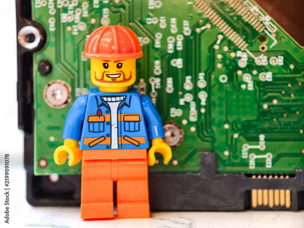 Obraz premium Russia, St. Petersburg, August 8, 2020 Lego figure standing next to a computer motherboard, great for tech-related illustrations