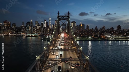 Queensboro Bridge traffic at dusk with New York City skyline and One World Trade Center