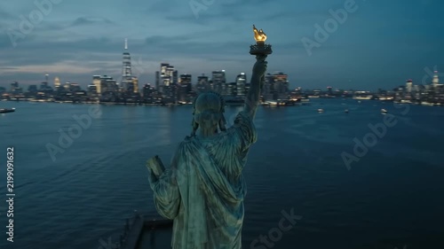 Statue of Liberty at dusk aerial view, iconic landmark, New York City skyline background