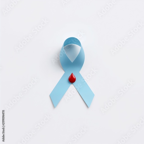 Awareness Ribbon With a Red Droplet on a Light Surface