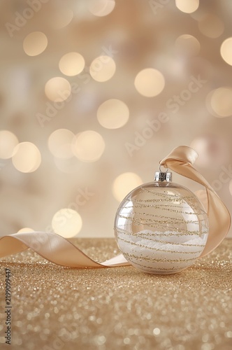 Shiny Holiday Ornament With Ribbon on Sparkling Table
