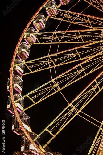 Rows of Glowing Passenger Cabins on a Giant Ferris Wheel at Night