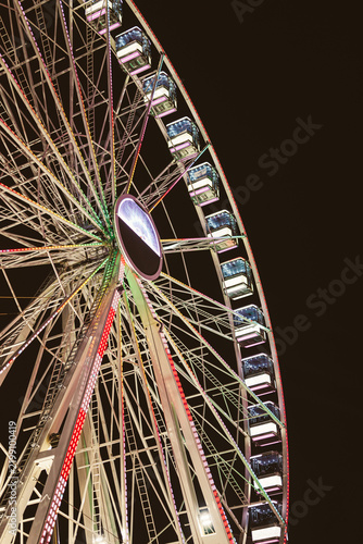 Illuminated Ferris Wheel Spinning at Night in Amusement Park