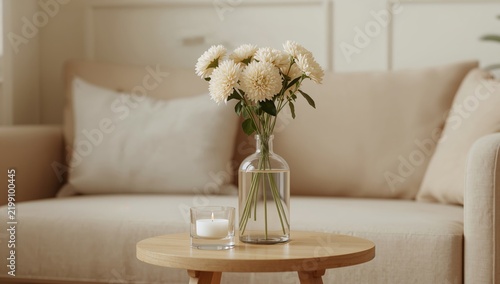 Flowers and Candle on a Small Table in a Living Room With a Light Sofa