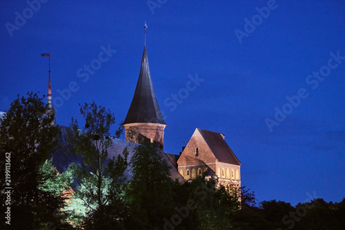 Foto Illuminated Konigsberg cathedral at twilight in Kaliningrad with deep blue eveni