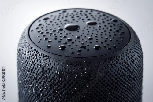 Waterproof speaker with water droplets under bright lighting