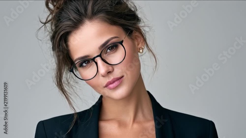 Intelligent Gaze: A sophisticated woman with dark, styled hair and modern glasses exudes confidence and intellect, her sharp eyes focused intently forward.