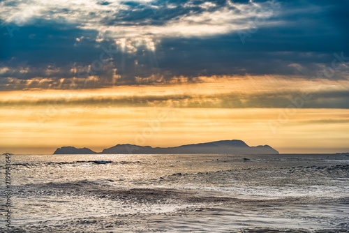 Dramatic landscape at sunset in the Pacific Ocean with San Lorenzo Island in the distance, seen from the La Pampilla beach in Lima, Peru