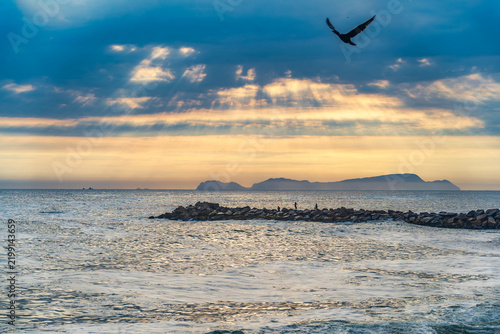 Dramatic landscape at sunset in the Pacific Ocean with San Lorenzo Island in the distance, seen from the La Pampilla beach in Lima, Peru