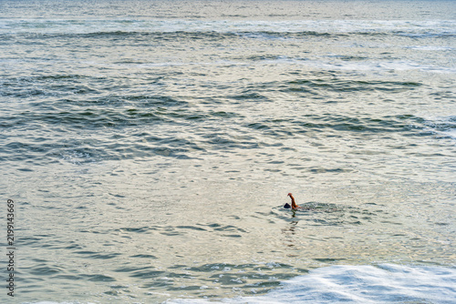 A single swimmer doing a freestyle stroke in the vast Pacific ocean open water off the coast of Miraflores, Lima.