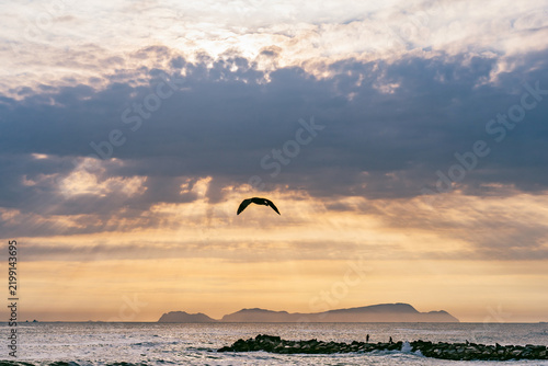 Dramatic landscape at sunset in the Pacific Ocean with San Lorenzo Island in the distance, seen from the La Pampilla beach in Lima, Peru