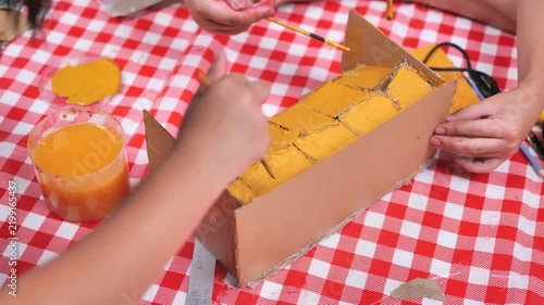 Children painting cardboard box craft project orange color creative activity