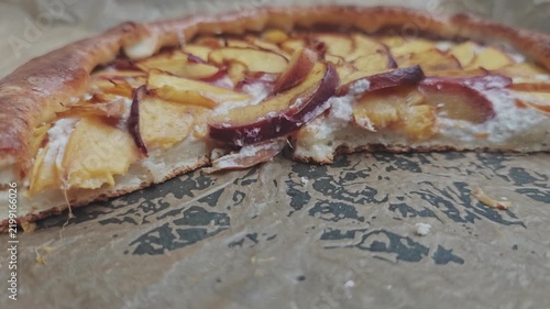 Delicious homemade fruit galette with peaches and cottage cheese on baking paper. Close up of a fresh, tasty, and rustic sweet dessert pie