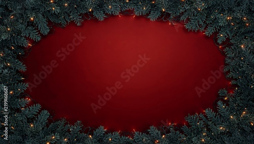 Holiday Decorations With Green Pine Leaves and Warm Lights on Red Background