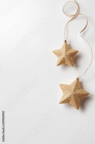 Golden Star Ornaments Hanging on a White Background for Holiday Decoration
