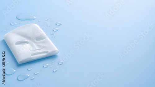 Facial Sheet Mask with Water Drops on Light Blue Background for Skincare Concept