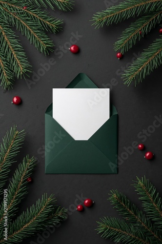 Green Envelope With Blank Card Among Pine Branches and Red Berries