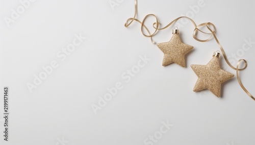 Two Star Ornaments and Ribbon on a Plain Background
