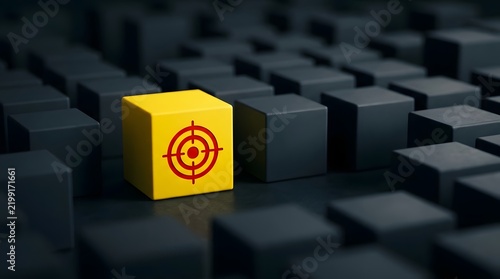 One bright yellow cube featuring a red bullseye design is prominently positioned amidst an array of uniformly dark gray cubes  emphasizing its distinctiveness through color and pattern contrast