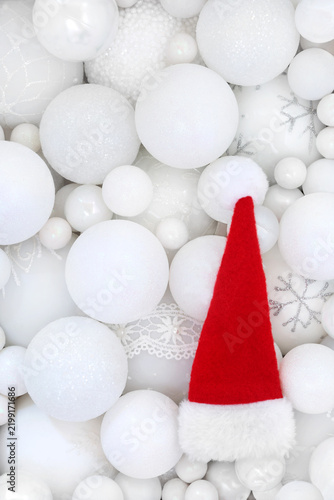 Santa hat and white Christmas sparkling tree sphere shape bauble decorations. Fun festive Xmas background for greeting card