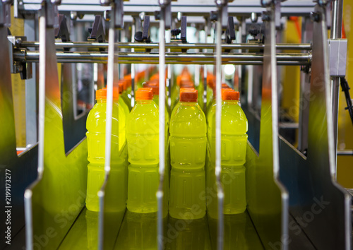 Production line conveying yellow energy drink bottles