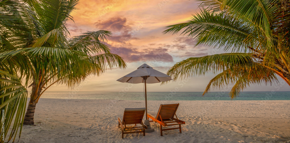 Obraz premium Idyllic tropical love beach sunbeds umbrella palm trees turquoise sea white sand sunny sky summer paradise resort. Perfect summer vacation travel scene. Luxury relax couples honeymoon coastal getaway
