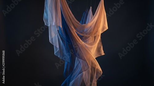 Abstract flowing sheer fabric with orange and blue light