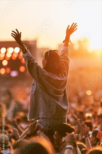 Young woman enjoying an outdoor music festival at sunset