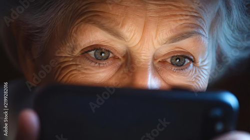 Elderly Woman Focuses on Smartphone Screen Wrinkles Highlighted