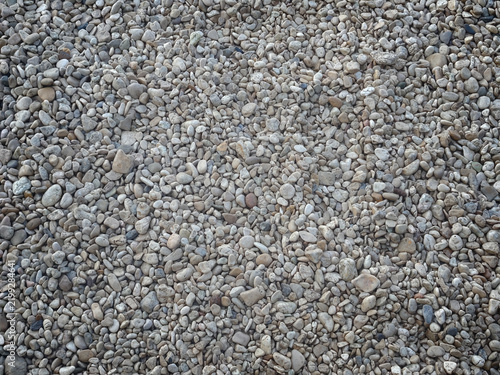 A textured background of small smooth grey pebbles and stones, symbolizing natural stability and earthy resilience.