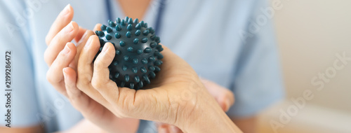 Canvas Print Close up of a physical therapist helping a patient exercise with a spiky massage ball for hand rehabilitation, occupational therapy and stroke recovery medical concept