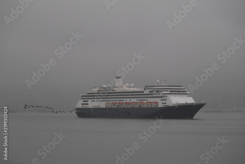 Classic luxury cruiseship cruise ship liner Zaandam Volendam arrival to Vancouver, BC after Alaska wilderness adventure Last frontier landscape nature scenery cruising with low hanging clouds misty