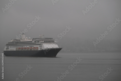 Classic luxury cruiseship cruise ship liner Zaandam Volendam arrival to Vancouver, BC after Alaska wilderness adventure Last frontier landscape nature scenery cruising with low hanging clouds misty