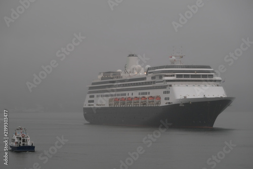 Classic luxury cruiseship cruise ship liner Zaandam Volendam arrival to Vancouver, BC after Alaska wilderness adventure Last frontier landscape nature scenery cruising with low hanging clouds misty