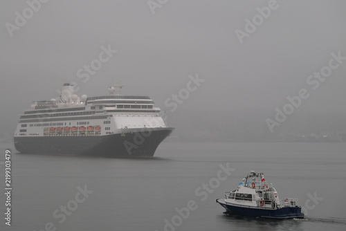 Classic luxury cruiseship cruise ship liner Zaandam Volendam arrival to Vancouver, BC after Alaska wilderness adventure Last frontier landscape nature scenery cruising with low hanging clouds misty