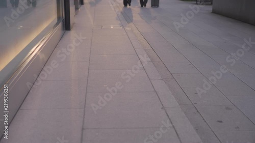 夕暮れの歩道を歩いて行く女性