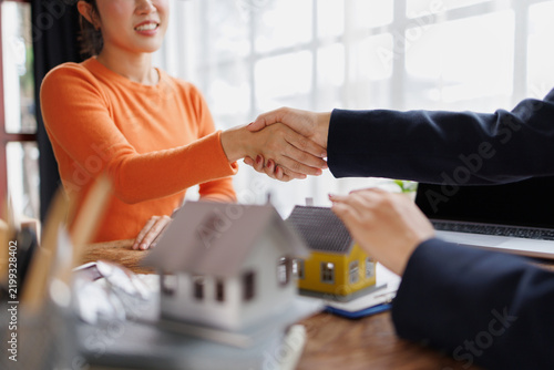 Bild auf Leinwand Business professionals shaking hands, sealing a real estate agreement over a hou