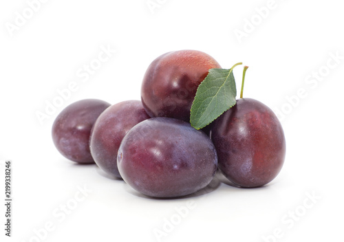 Fresh ripe plum fruits with green leaf isolated on white background.