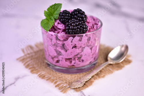 Summer blackberry sorbet with fresh berries on a light background. Close-up.
