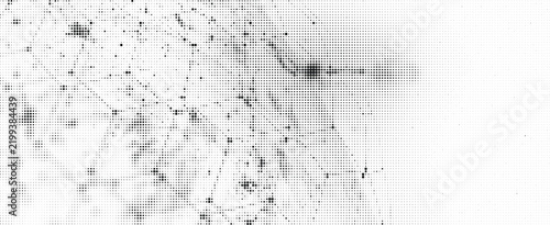 Abstract halftone background with black dots of varying sizes creating a textured pattern on a white surface