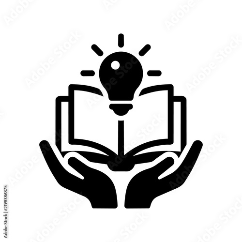Black icon of hands holding open book with glowing lightbulb representing support for education and wisdom