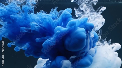 Abstract Ink Diffusion: A dynamic swirl of vibrant blue and ethereal white ink dissolves and disperses in water, creating an abstract and mesmerizing cloud-like formation.