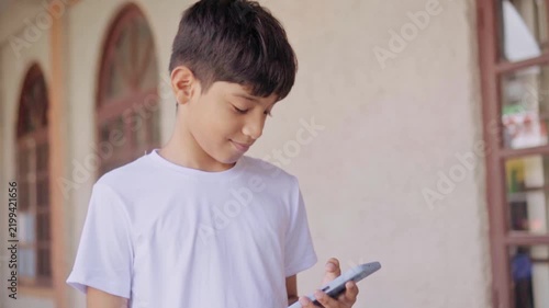 Young boy using a smartphone outdoors