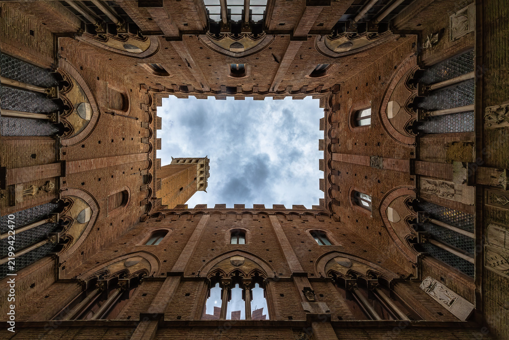 Obraz premium A lookup at the atrium of Palazzo Pubblico (town hall) palace in Siena historic center, Tuscany, Italy